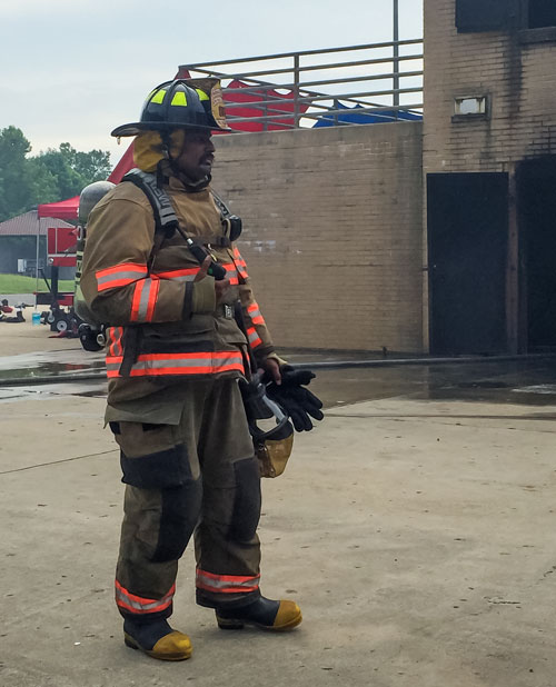 Bharat Kumar wears firefighter equipment while volunteering.