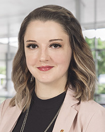 Professional portrait of Hilary Lentz, a woman in dark shirt and pink blazer.