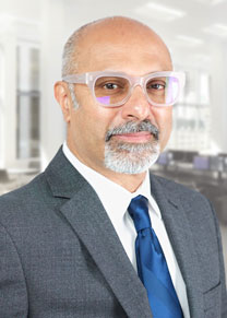 Portrait of Huzefa Irfani, AIA wearing a gray suit, white shirt and blue tie smiling.