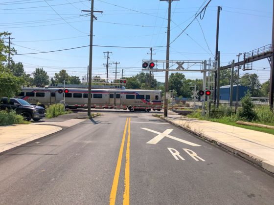A SEPTA train passing by a railroad crossing.