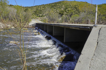 A side view of the Sandia Creek Bridge over Santa Margarita River on a sunny day.